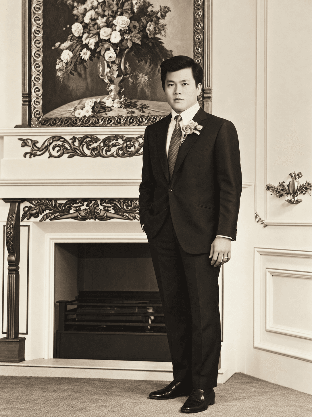 Robert as a young man in a suit, standing beside a fireplace